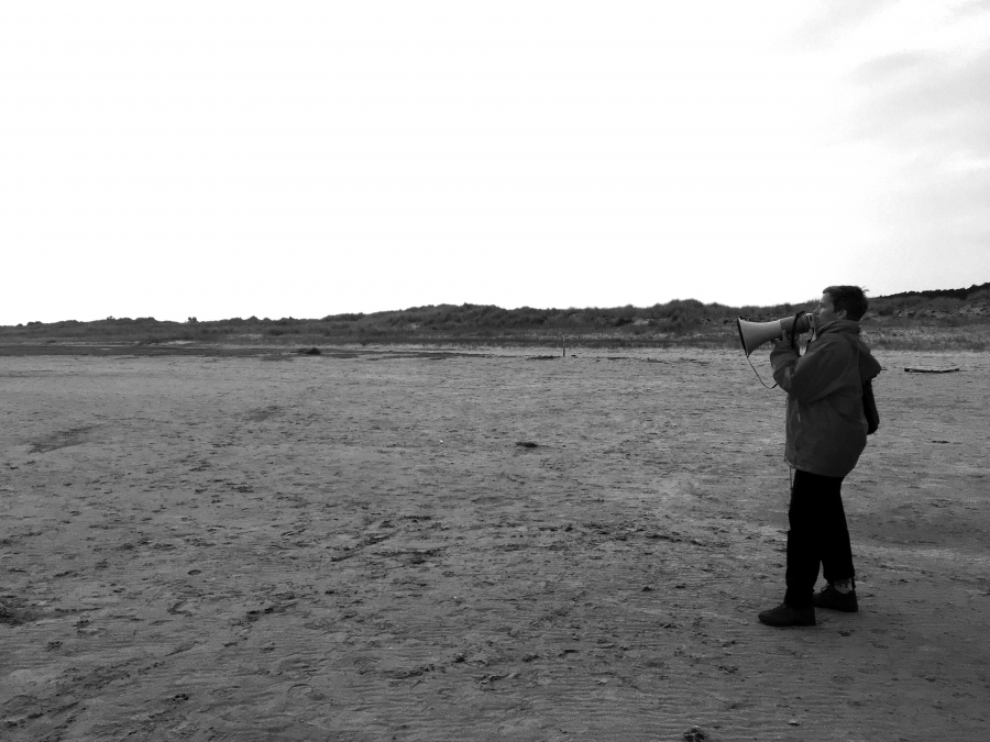 Nicol Beutler met megafoon op het strand van Terschelling.